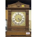 An oak cased mantel clock, the brass dial with silvered chapter ring, the German movement with count