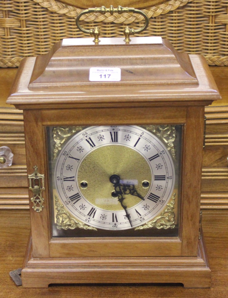 A mahogany mantel clock, in the George II style, with brass handle and domed top, the brass dial