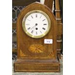 An inlaid mahogany mantel timepiece, the arched case with shell motifs, the enamelled dial with