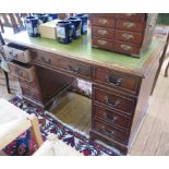 A mahogany veneered pedestal desk, the leather inset rectangular top over beaded drawers and bracket