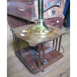 A mahogany table top revolving bookcase, with shaped top, 38cm square, and a brass table lamp,