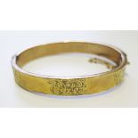A 9 carat gold bangle with cased decoration