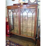 A mahogany bowfront display cabinet, the raised back over a gadrooned edge and a pair of glazed