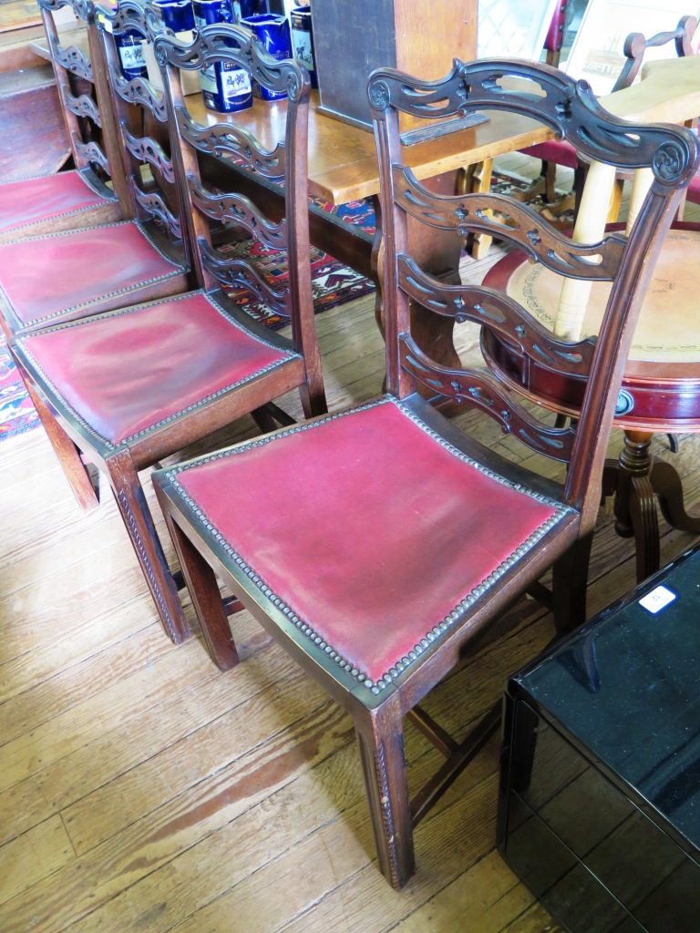 A set of four George III style ladder back dining chairs, the pierced rails over dished seats on