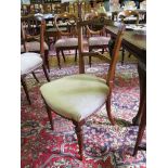 A pair of Edwardian walnut salon chairs, the rounded carved rails above stuffover seats and fluted