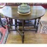 An oak drop leaf table, the oval top on baluster turned and block legs (frieze drawer missing)