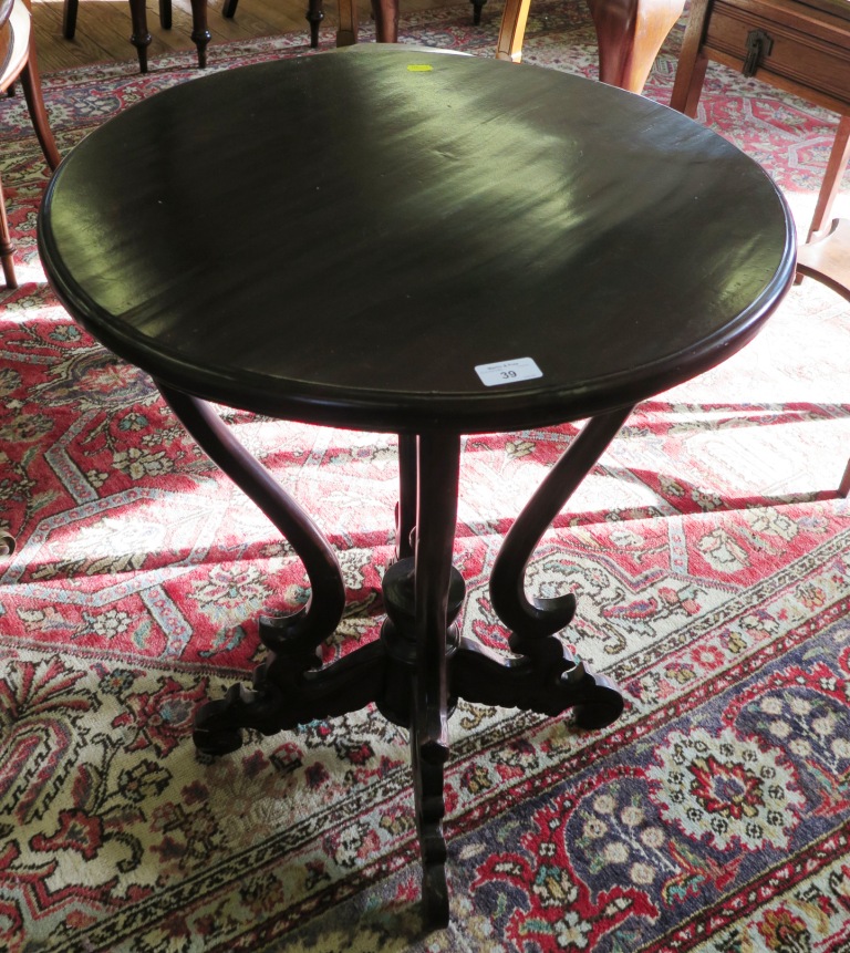 A Victorian style stained wood occasional table, the circular top over four scroll supports and legs