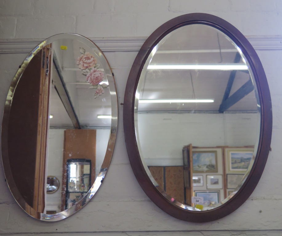 A mahogany oval wall mirror with bevelled plate and another oval mirror, 74.5cm x 52cm