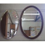 A mahogany oval wall mirror with bevelled plate and another oval mirror, 74.5cm x 52cm