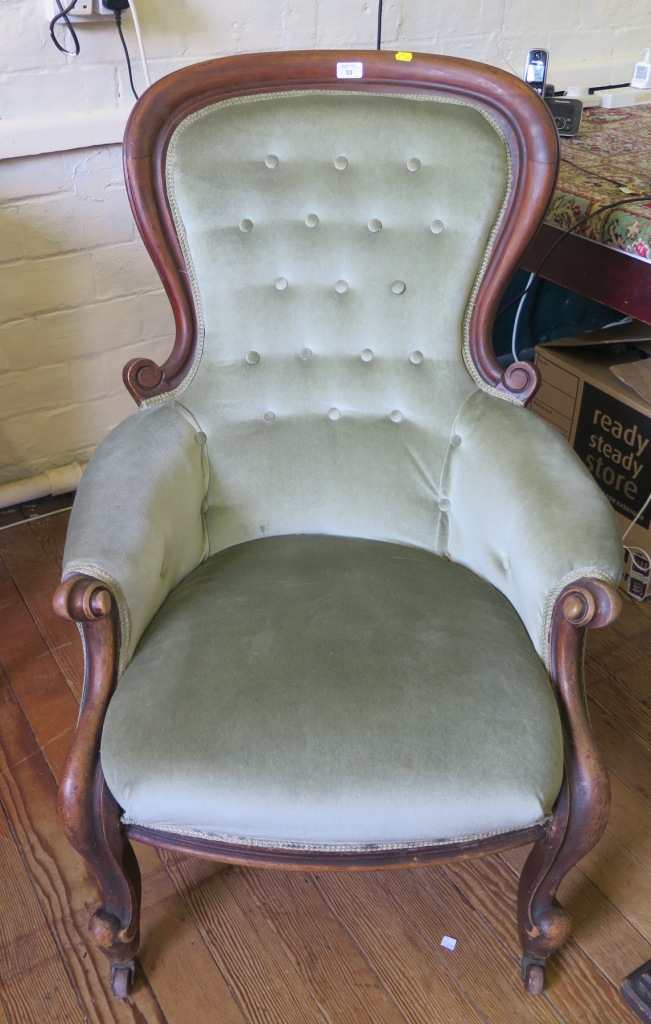 A Victorian mahogany spoonback armchair, the scrolling button back on moulded scroll supports and