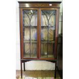 An Edwardian mahogany and painted display cabinet, the raised back over a pair of glazed doors and