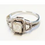 A 14 carat white gold ring set with centrally set emerald cut diamond and baguette diamonds to