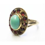 A gold colour metal ring set with turquoise and garnet