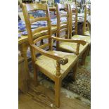 A set of six ladderback dining chairs, including two carvers, with rush seats, metal stretchers