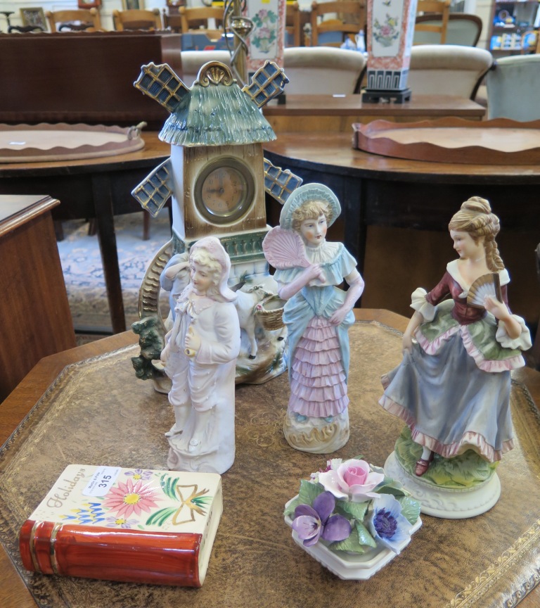 A continental ceramic table clock in the form of a windmill, with a figure and mule below, 35cm