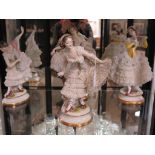 A set of four German porcelain figures of dancers, with exuberant lace dresses, 30cm high