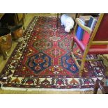 A Mehran carpet with two rows of five medallions on a red field and ivory border, 326cm x 166cm