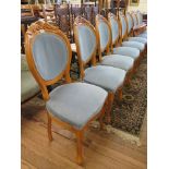 Set of eight stained beech dining chairs, with blue upholstery, the scroll carved oval backs on