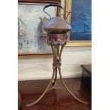 A late Victorian copper and brass kettle and stand, the hammered kettle stamped T&Co on a outswept
