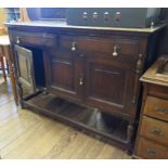 An oak sideboard, the raised back over two frieze drawers and two cupboard doors on turned and block