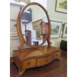 A George III style satinwood and ebony strung toilet mirror, the oval plate above a serpentine