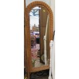 A wicker and iron cheval mirror, with arched plate and scrolled supports, 155cm