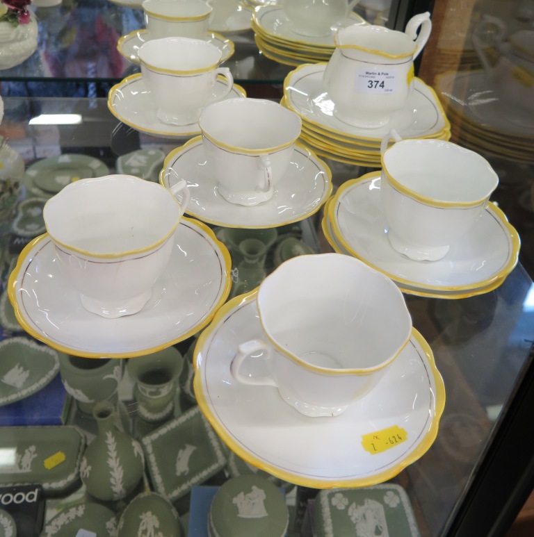 A Royal Albert service with yellow and gilt rims, for six places (one cup missing)