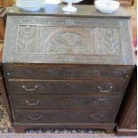 An oak bureau, with later floral and lunette carving, the sloping fall front enclosing a stepped