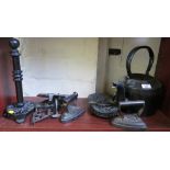 A cast iron kettle, irons, trivets and stands
