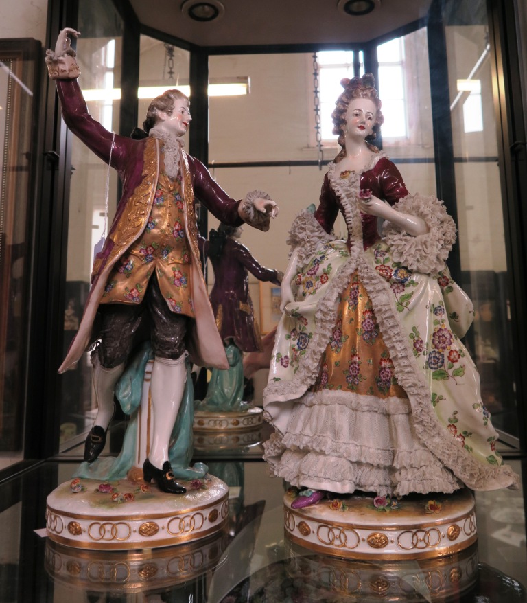 A pair of German porcelain figures dancing, wearing a purple coat and purple lace dress, the lady