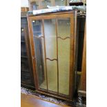 A 1920s walnut display cabinet, with glazed door and sides on moulded bracket feet, 57cm wide