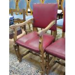 A set of six Commonwealth style oak chairs, including two carvers, the leatherette upholstered backs
