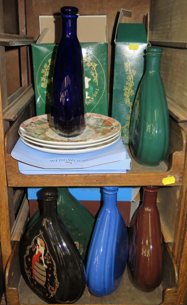 A collection of Courvoisier ceramic display flasks and three Wedgwood plates