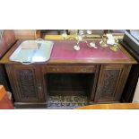 An Edwardian mahogany kneehole desk, the leather inset top over a central drawer flanked d by floral