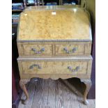 A burr walnut bureau, the shaped top over a carved edge fall, two short and one long drawer on