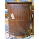 A mahogany bowfront corner cupboard, with panelled door, 44cm wide x 64cm high