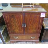 A flame mahogany and crossbanded TV cabinet, the rising front imitating a pair of doors above a long