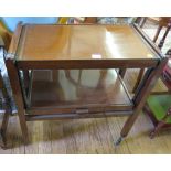 A mahogany two tier patent tea trolley, converting into a table, on castors, 69cm wide