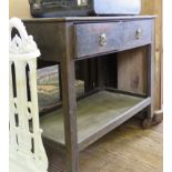 An oak table trolley, the top with hinged flap over two frieze drawers, a shelf and castors, 78cm