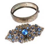 A silver bangle and costume brooch