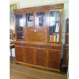 A yewwood veneered crossbanded side cabinet, the dentil cornice over four glazed doors and drinks