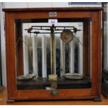 A set of Griffin & Tatlock brass laboratory analytical balances with Bakelite base within a mahogany