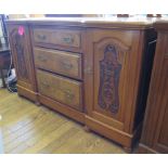 An Edwardian walnut inverted breakfront sideboard, with three graduated drawers flanked by foliate