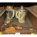 Two lidded German Steins, four continental pipes and a wooden snuff box