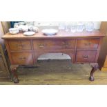 A Georgian style mahogany kneehole desk, the rectangular top with indented corners, above an