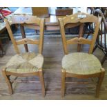 A pair of continental beech side chairs, the shaped top and mid rails over rush seats on square