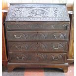 An oak bureau, with later floral and lunette carving, the sloping fall front enclosing a stepped