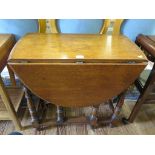 An oak gateleg table, the oval top on baluster turned and block legs, 77cm wide