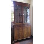 A mahogany bookcase cabinet, the dentil cornice over a pair of glazed doors, the base with frieze