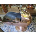 A copper coal helmet with turned ebonised handles and pedestal foot, and a copper shovel (2)